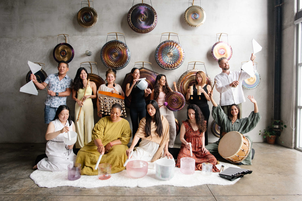 A training cohort celebrating together in front of the gong wall