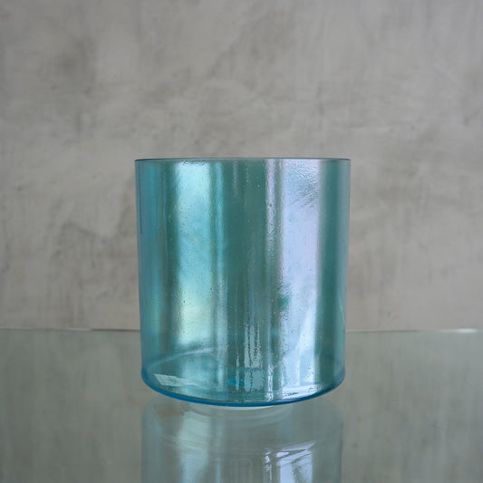 Crystal Tones 7-inch E+5 crystal singing bowl in Aqua Aura Gold, side view on a glass shelf