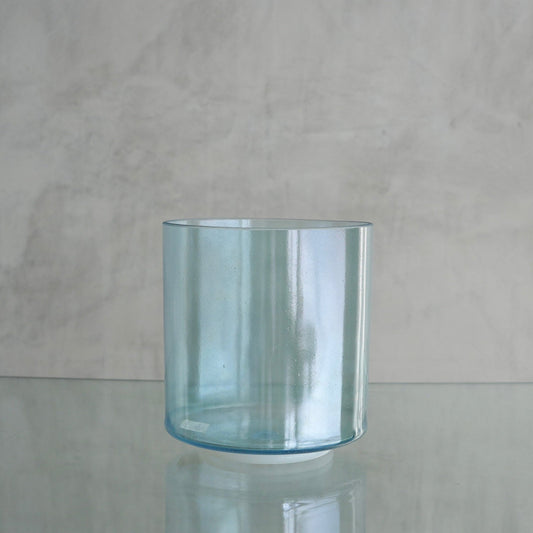 Crystal Tones 7-inch E+5 crystal singing bowl in Aqua Aura Gold, side view on a glass shelf
