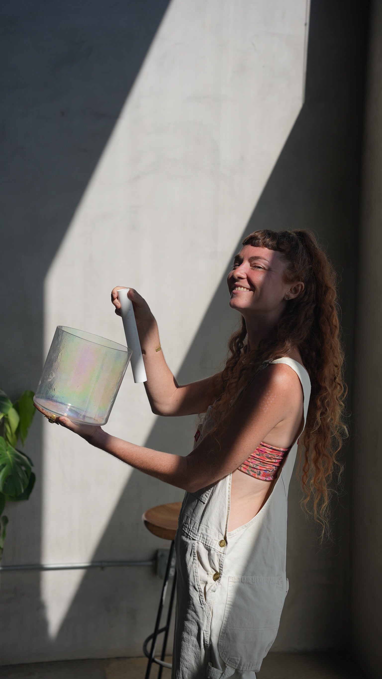 Smiling Woman Playing a Single Singing Bowl - Join OSO Sound Healing's Inner Circle for Exclusive Invitations and Transformative Insights.